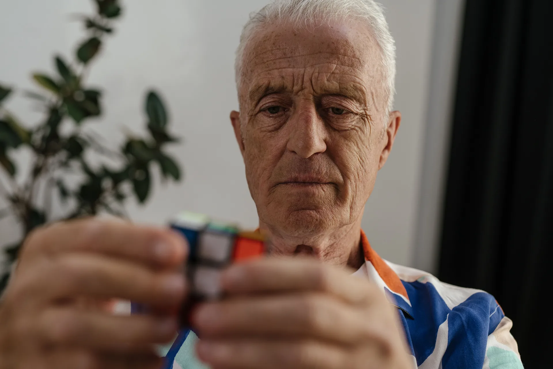 Older adult focused on solving a Rubik’s cube during cognitive rehabilitation