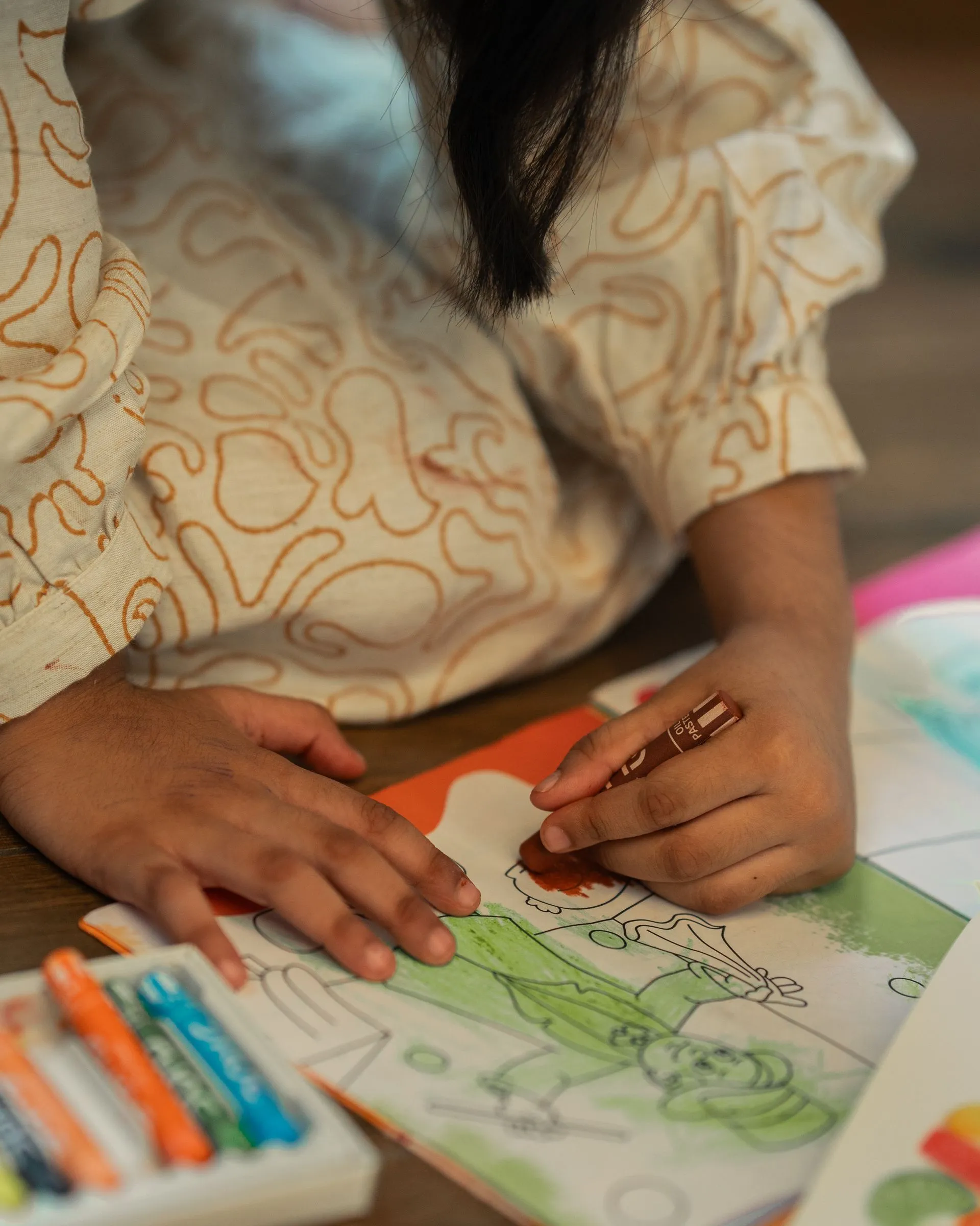 Niño dibujando con crayones de colores en terapia infantojuvenil