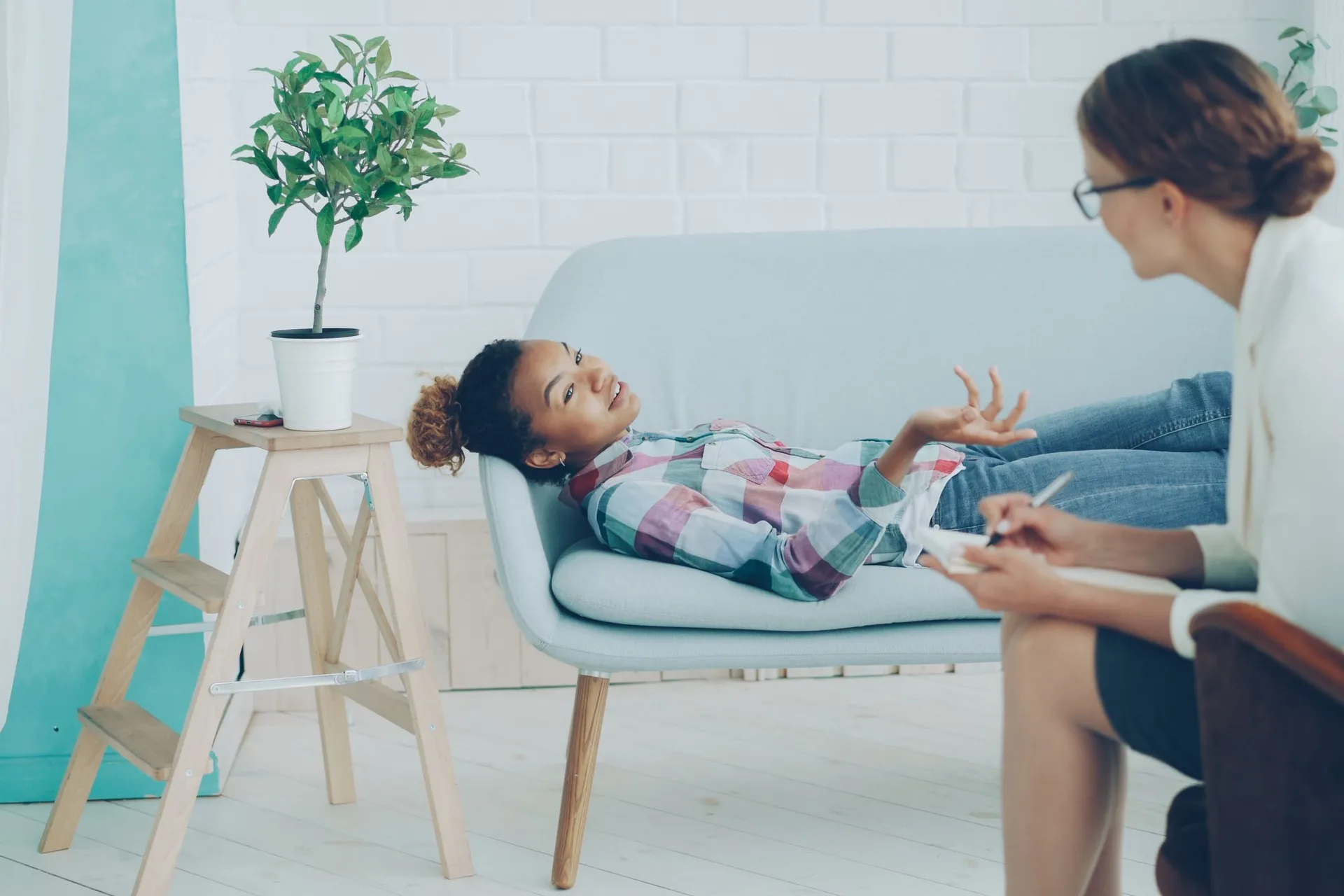 In-person therapy session between therapist and client in a cozy office